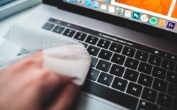 person wiping down keyboard